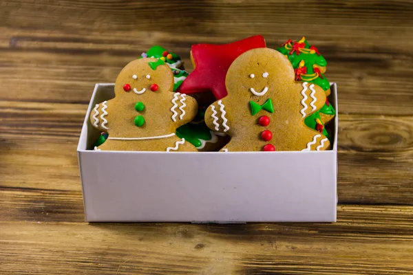 คุกกี้ขนมปังขิงคริสต์มาสอร่อยในกล่องบนโต๊ะไม้ — ภาพถ่ายสต็อก