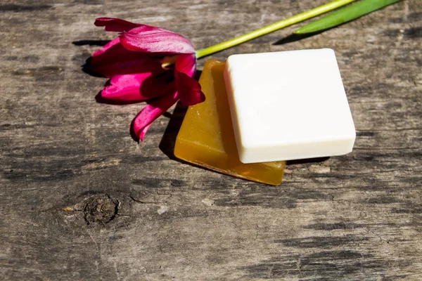 天然肥皂和红郁金香花在乡村木桌上的两条 — 图库照片
