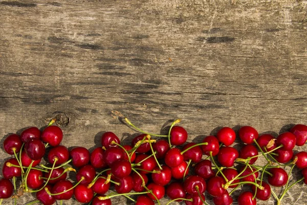 Röda körsbär frukter på trä bakgrund — Stockfoto