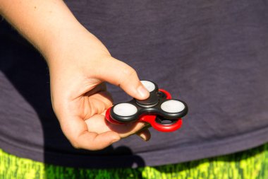 Çocuk iki topluca spinner ile oynarken stres giderici oyuncaklar açık