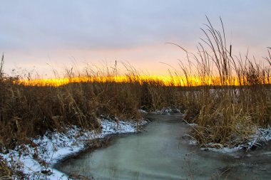 Kış nehrinin üzerinde gün batımı