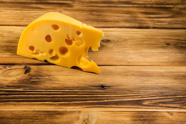 Stukje kaas op de houten achtergrond — Stockfoto