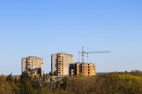 Gru e edificio in costruzione contro il cielo blu — Foto Stock