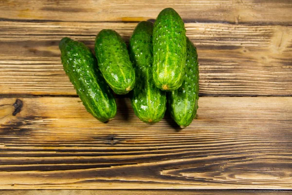 Färska gurkor på träbord — Stockfoto