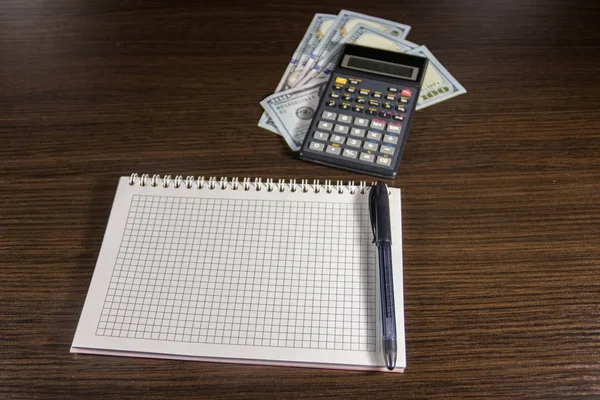 Notebook z dolarów, pióra i Kalkulator na biurko — Zdjęcie stockowe
