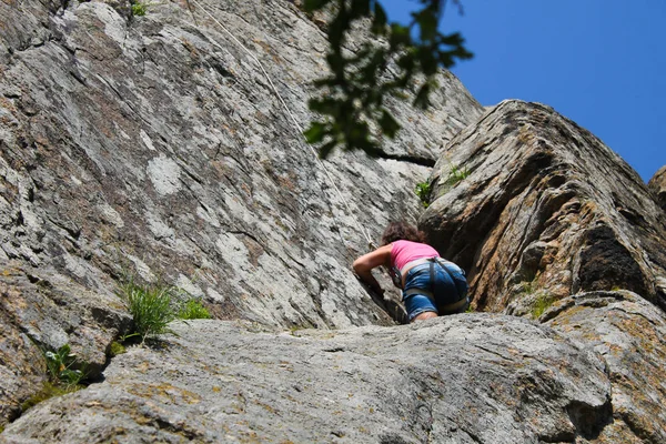 Chica escalador escalada en una roca —  Fotos de Stock