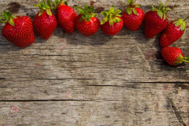 Rustik ahşap arka plan üzerinde olgunlaşmış taze çilek