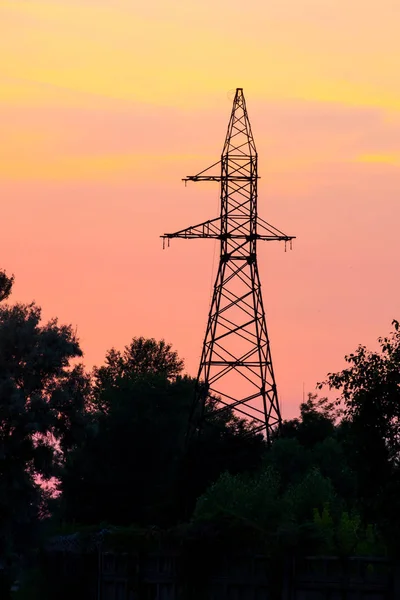 High voltage power tower at sunset
