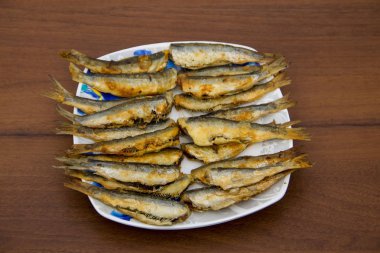 Ahşap arka plan üzerine bir tabak kızarmış Baltık ringa