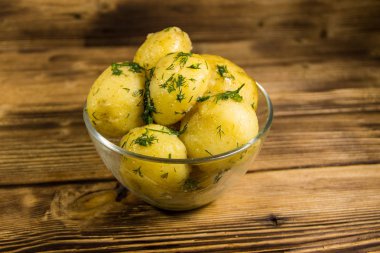 Tereyağı ve ahşap masa üzerine dereotu ile yeni haşlanmış patates