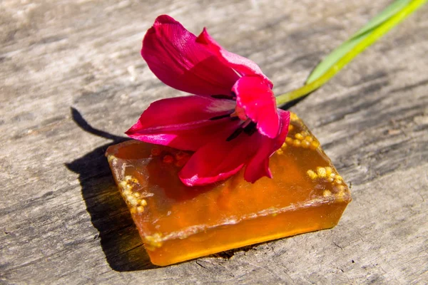 Sapone fatto a mano e fiore di tulipano rosso su sfondo in legno rustico — Foto Stock