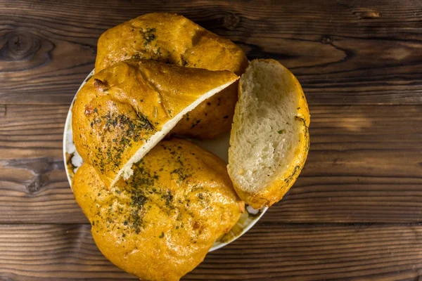 Pão fresco ciabatta em uma chapa na mesa de madeira — Fotografia de Stock