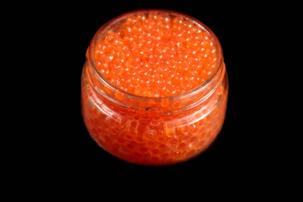 Caviar vermelho em frasco de vidro isolado no fundo preto — Fotografia de Stock