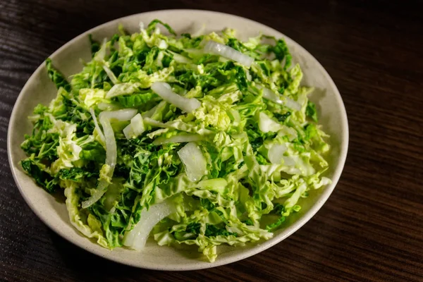 Ensalada con col salada y cebolla sobre mesa de madera —  Fotos de Stock