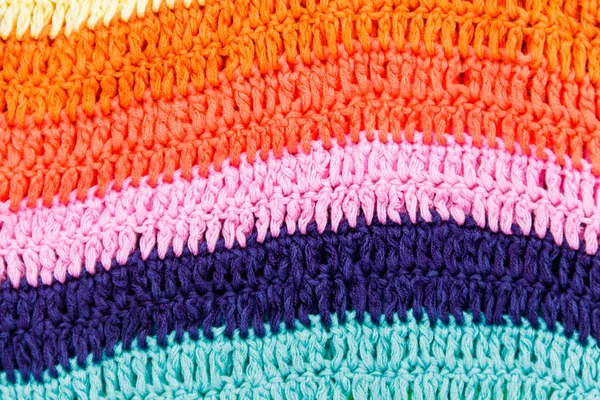 Crocheted multi colored striped fabric texture for background