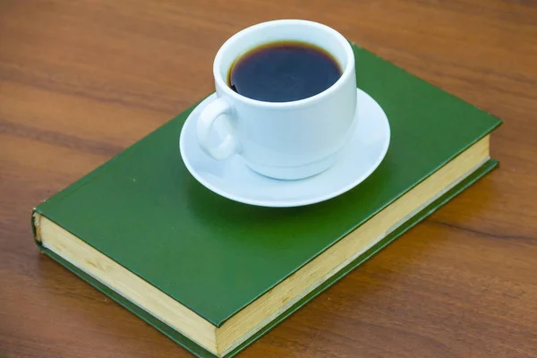 Taza de café y libro sobre mesa de madera — Foto de Stock