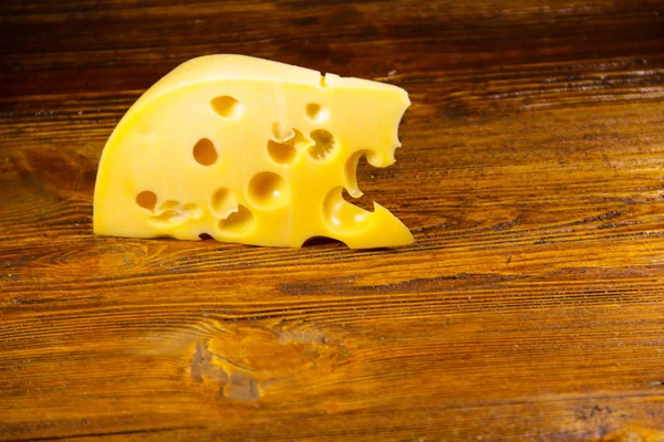 Pedaço de queijo no fundo de madeira — Fotografia de Stock