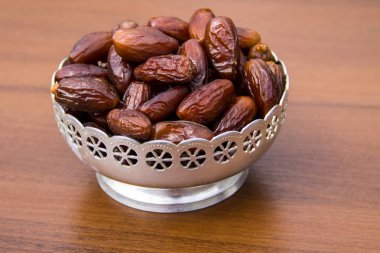 Tahta masadaki gümüş kasede meyvelerle çıkıyor. Müslümanların kutsal Ramazan Kareem ziyafeti.