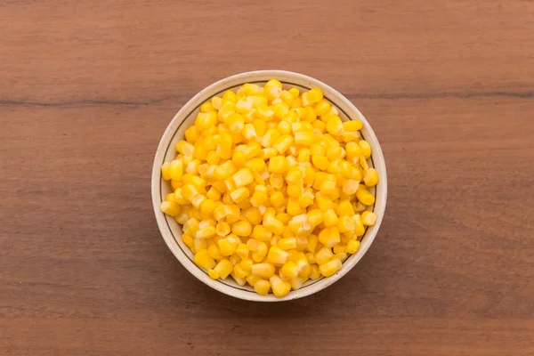 Canned sweet corn in a bowl on wooden table — Stock Photo, Image