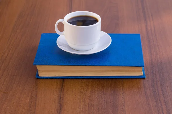 Taza de café y libro sobre mesa de madera — Foto de Stock