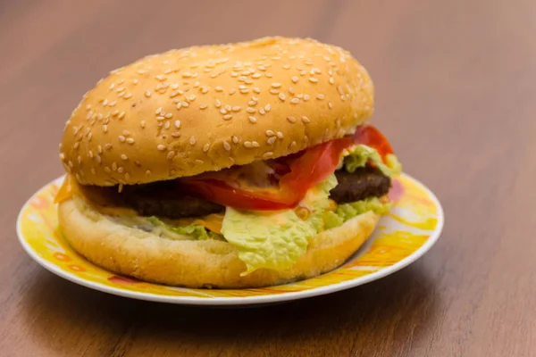 Delicious hamburger or sandwich on plate on wooden table — Stock Photo, Image