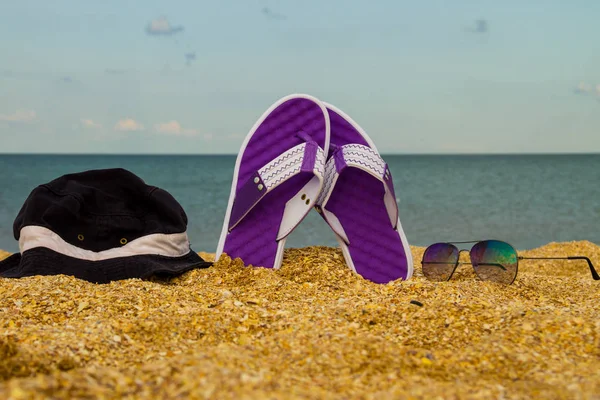 Paar Flip-Flops, Hut und Sonnenbrille am Sandstrand — Stockfoto