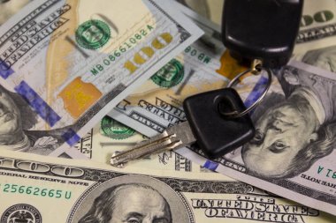 Amerikan yüz dolar faturaları arka plan üzerinde araba anahtar halkası ile anahtar
