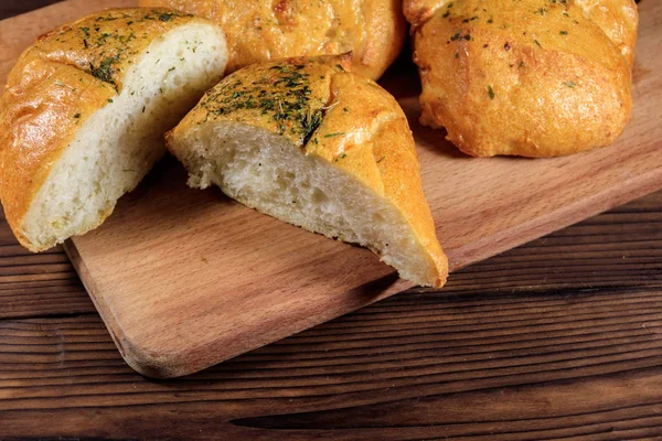 Pão ciabatta fresco na tábua de corte em mesa de madeira — Fotografia de Stock