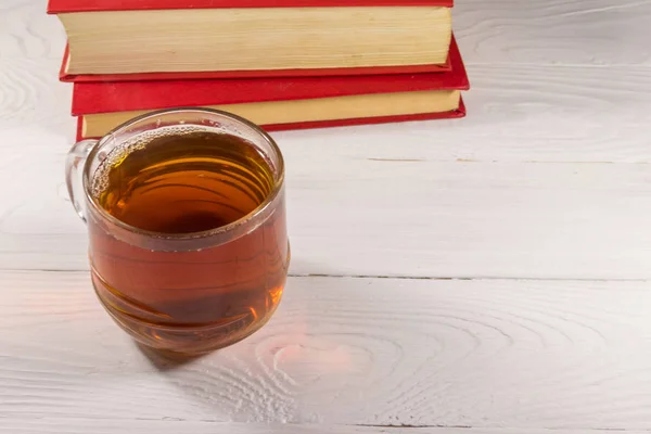 Tasse Tee und Buch auf weißem Holztisch — Stockfoto