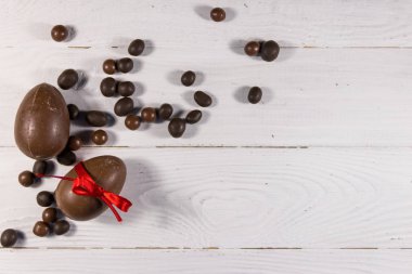Beyaz ahşap arka planda çikolata yumurtalı Paskalya kompozisyonu