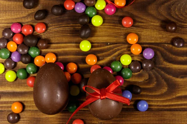 Пасхальная композиция с шоколадными яйцами на деревянном фоне — стоковое фото