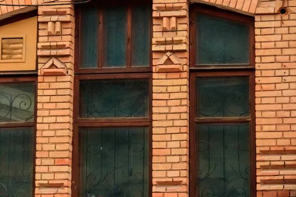 Γκρο πλαν, παλιό παράθυρο στην πρόσοψη ενός κτιρίου κόκκινο τούβλο — Φωτογραφία Αρχείου