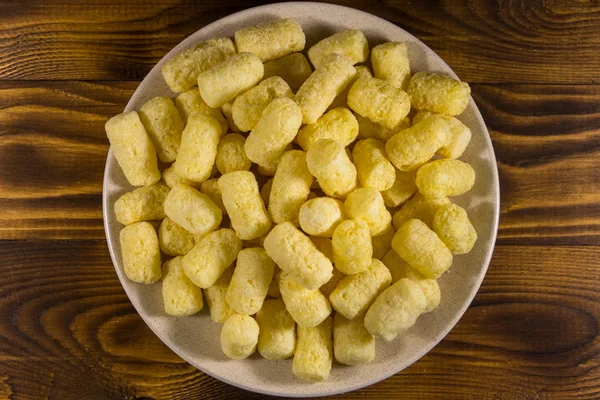 Palitos de maíz dulce en un plato sobre una mesa de madera — Foto de Stock