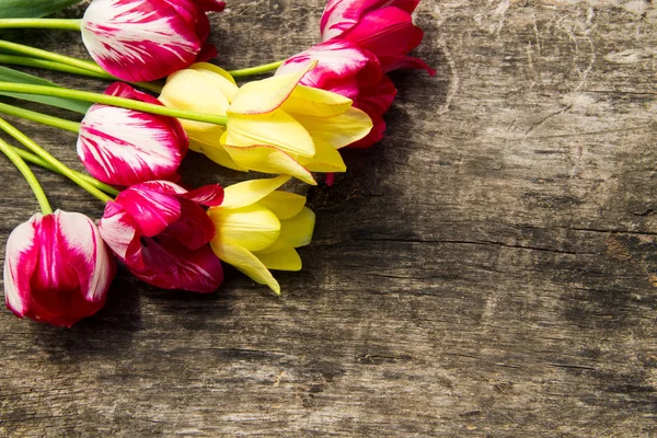 Red and yellow tulips on rustic wooden background — Stock Photo, Image