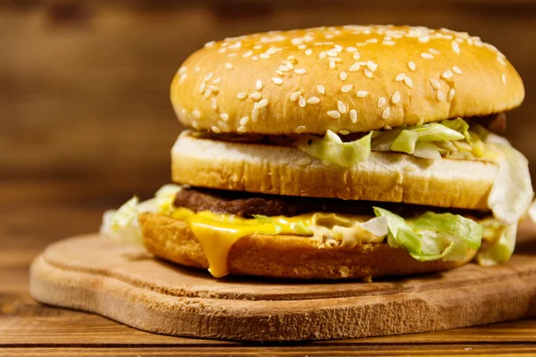 Leckerer großer Hamburger auf Holztisch — Stockfoto