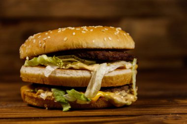 Ahşap masada lezzetli büyük hamburger.