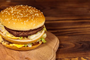 Ahşap masada lezzetli büyük hamburger.