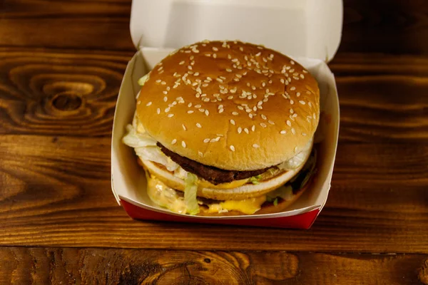 Leckere große Hamburger in Pappschachtel auf Holztisch — Stockfoto