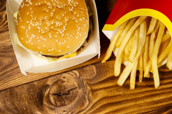 Grand hamburger et frites sur table en bois — Photo