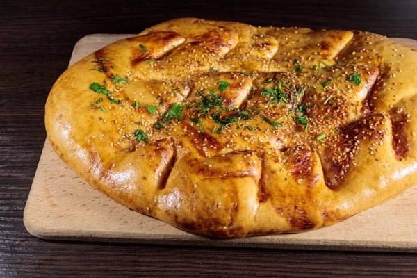 Pan de pita sobre tabla de cortar sobre mesa de madera — Foto de Stock