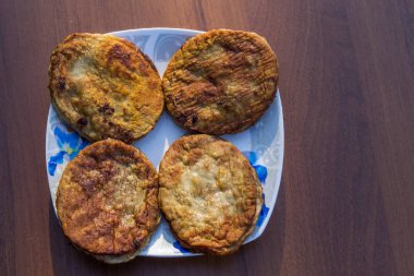 Ahşap masa üzerinde bir tabak içinde kızarmış pirzola. Üstten Görünüm