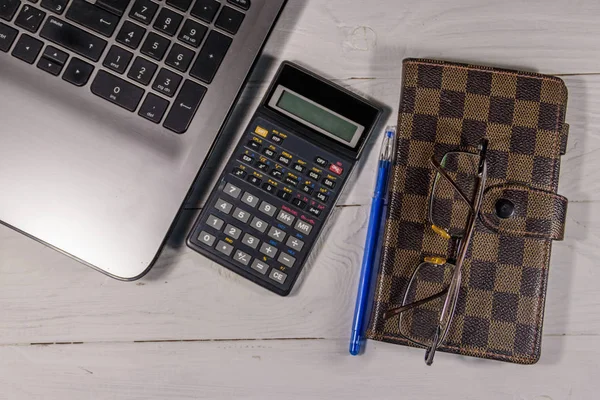 Witte Bureau met laptop, rekenmachine, het Kladblok, brillen en pen — Stockfoto