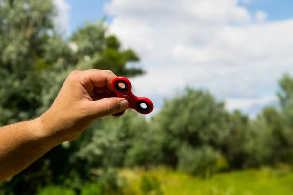 Hombre jugando con fidget spinner estrés aliviar juguete al aire libre —  Fotos de Stock