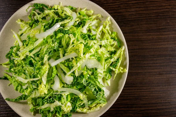 Salat mit Wirsing und Zwiebeln auf Holztisch — Stockfoto