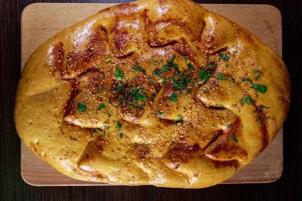 Pan de pita sobre tabla de cortar sobre mesa de madera — Foto de Stock