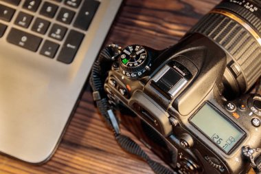 Ahşap arka planda dizüstü bilgisayar ve fotoğraf makinesi