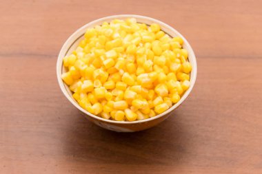 Ahşap masa üzerinde bir kase konserve mısır