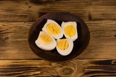 Ahşap masa üzerinde bir tabakta haşlanmış yumurta