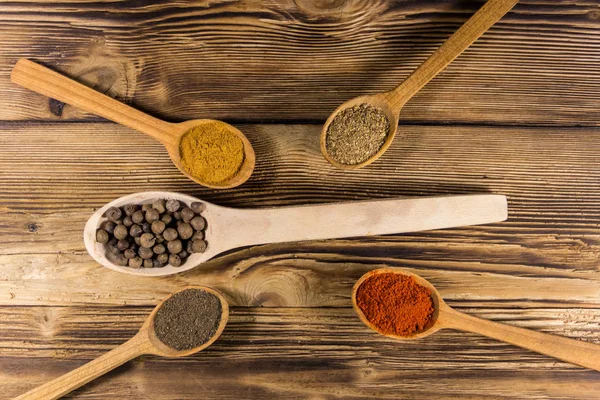 Assorted spices in wooden spoons on a table — Stock Photo, Image