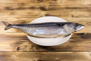 Scomber balık bir plaka üzerinde tuzlu. Ahşap masa üzerinde tüm uskumru
